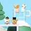 Four small animal figurines with hats around a clear glass mug on a blue background
