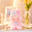 Pink plush toy with a bow on a decorative surface with 'LovelyEmma' branding.