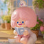 Cute character figurine with pink hair reading a book in a blurred indoor setting