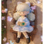 Plush toy of a character with light blue hair and a white dress sitting on a wooden chair.
