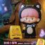 Toy figure of a character with cat ears and a 'Don't Touch' sign in a colorful setting