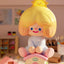 Toy figure of a character with blonde hair and a house-shaped base in a room setting.