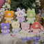 Set of colorful plush toys with animal-themed costumes on a decorative background with flowers and greenery.