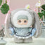Plush toy with large ears and a light blue outfit in a decorative setting