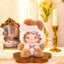 Stuffed animal toy with a fluffy white hood and brown body on a decorative stand, with 'Lovely Emma' branding.