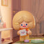 Toy figure with blonde hair holding a card in a room setting