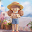 Toy figure of a girl with a straw hat and sunglasses, standing outdoors with flowers and a blurred background.