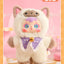 Plush toy with cartoon face and purple bow tie on a pink background
