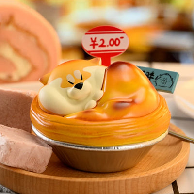 Cupcake with a dog-shaped decoration on top, priced at ¥2.00, on a wooden plate.