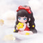 Toy figure with black hair, red bow, and star-shaped object on a white background