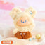 Plush toy with a bear-like design wearing a brown outfit on a soft, blurred background