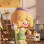 Toy figure with purple hair and green outfit in a room with toys and furniture