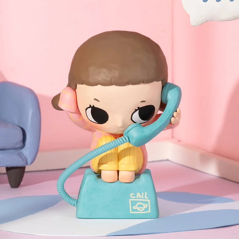 Toy figure of a character holding a blue phone against a pink background