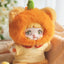 Toy figure with orange furry hood and white face, wearing a white outfit with paw print design.