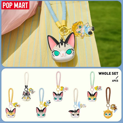 Set of cat-themed keychains with colorful straps on a yellow fabric background, featuring the Pop Mart brand.